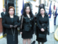 Tres mujeres vestidas de negro con sombreros tradicionales, posiblemente en una ceremonia religiosa o festiva.