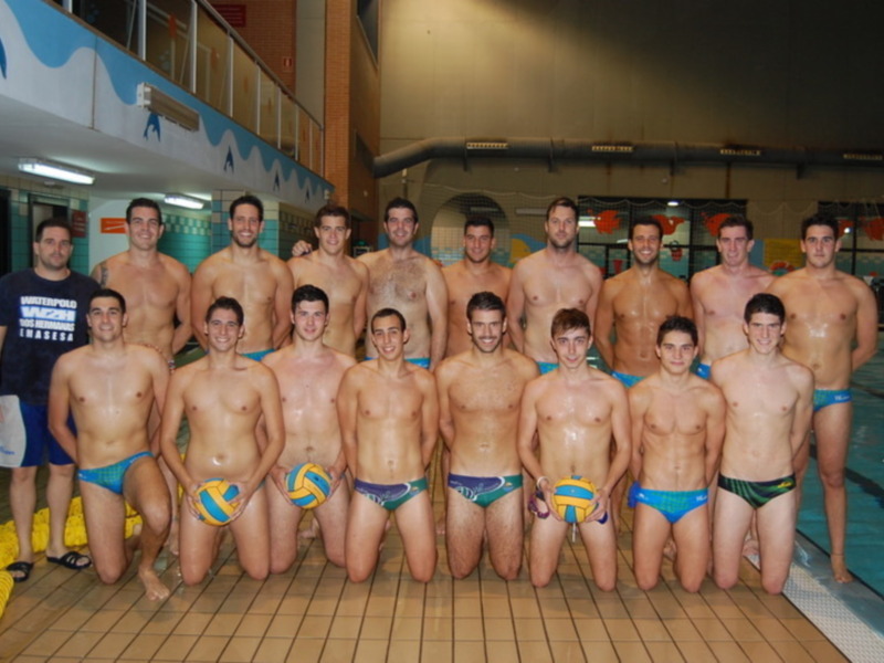 Equipo de natación masculina posando en la piscina.
