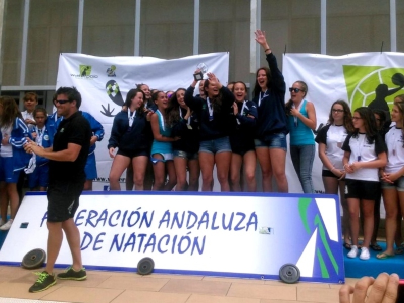 Equipo de natación celebrando con banderas y pancarta.
