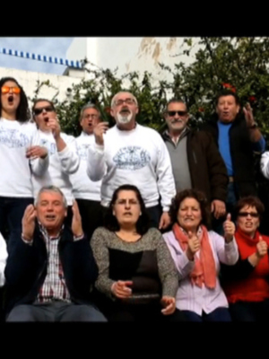 Grupo de personas celebrando juntos, vestidos con camisetas blancas y haciendo gestos de felicidad.
