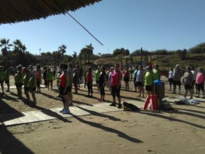 Grupo de personas realizando actividad física al aire libre en una playa.