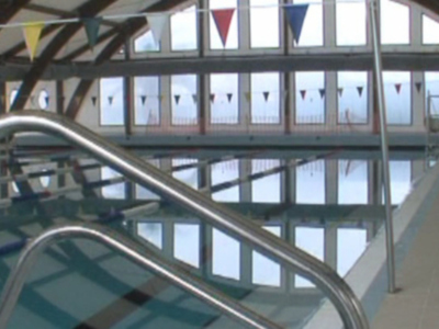 Piscina interior con banderas de colores en el fondo.