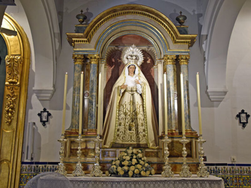 La Sevillana Virgen de las Tristeza vestida de blanco en tiempo estival.