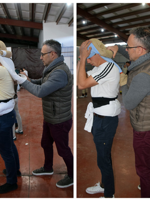 Persona ayudando a otra a ajustar un pañuelo en la cabeza en un espacio interior.