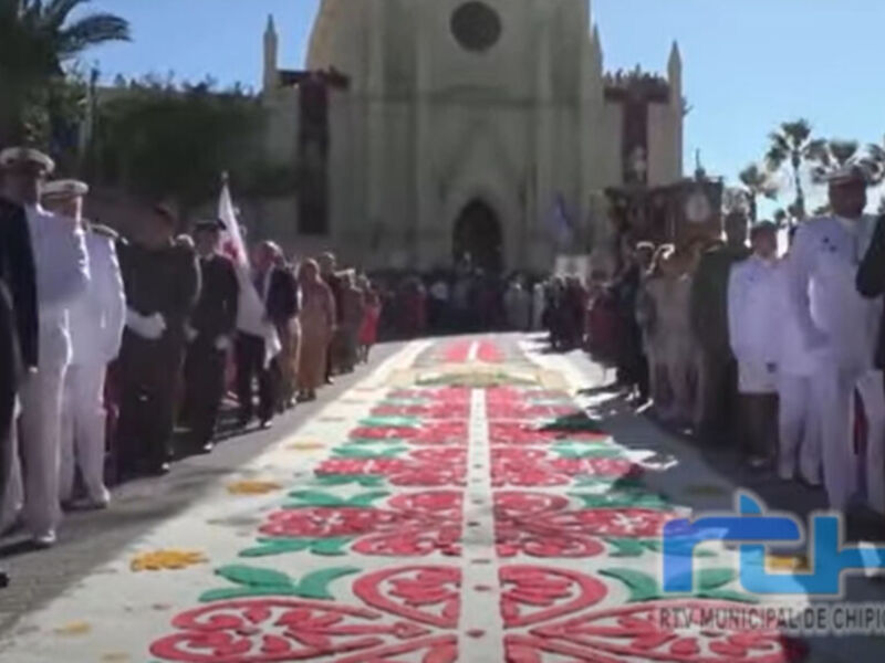 Fiesta de la Alhóndiga en Chipiona, con una alfombra de flores y figuras en el suelo.